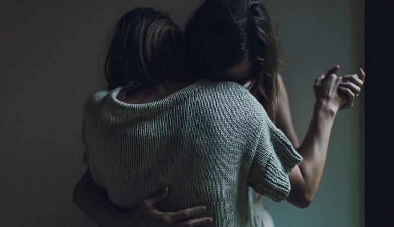 Two women, who are desperately hugging each other.