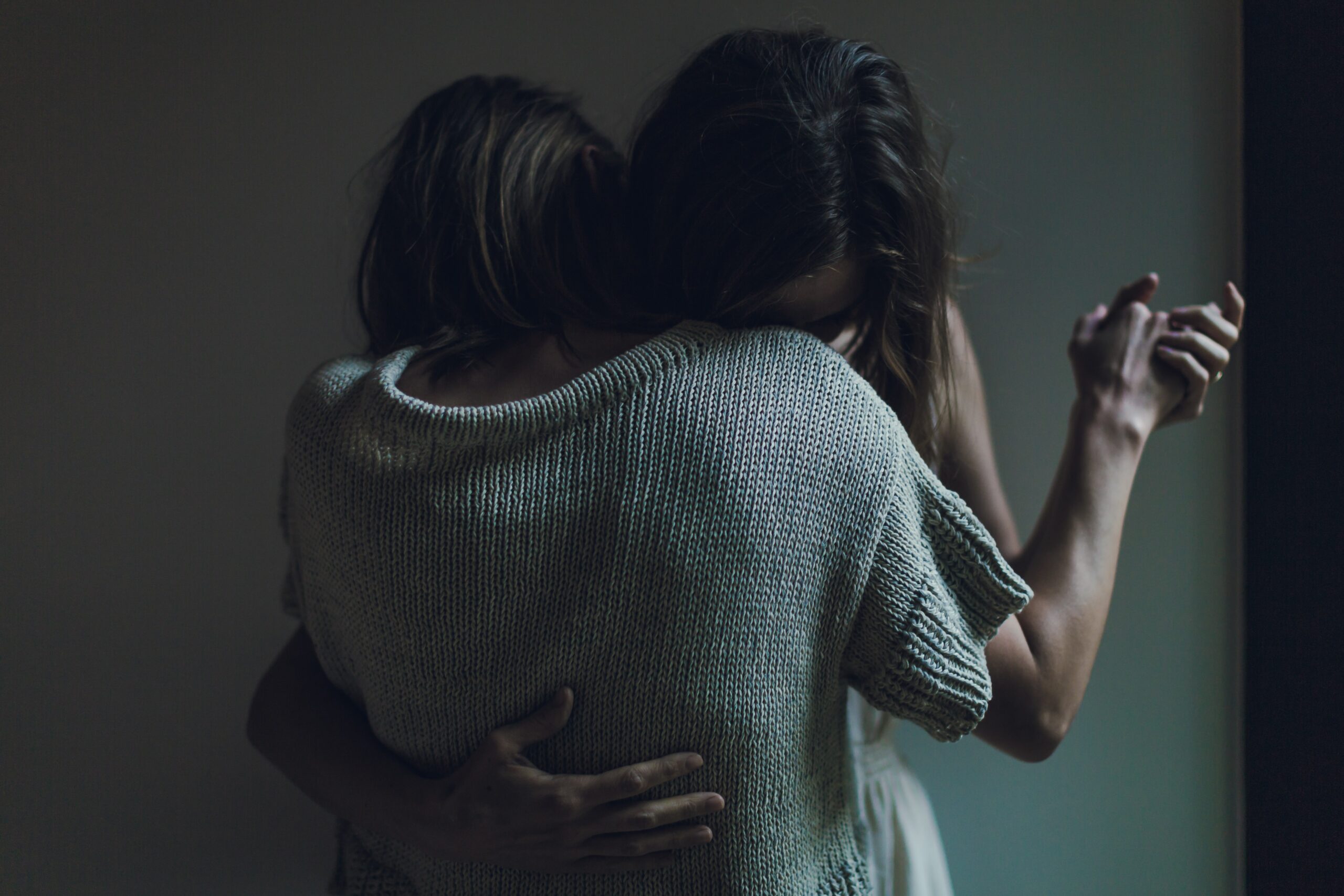 Two women, who are desperately hugging each other.