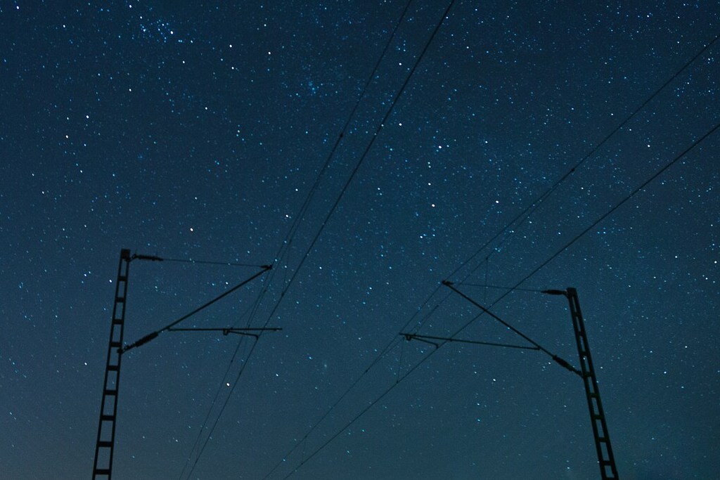 Railroad tracks in front of a starry sky